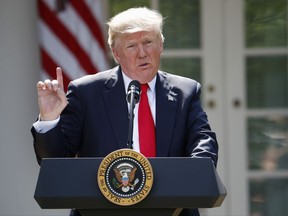 FILE - In this Thursday, June 1, 2017 file photo, President Donald Trump speaks about the U.S. role in the Paris climate change accord in the Rose Garden of the White House in Washington. A new Associated Press-NORC poll finds that Americans want local officials to do more to battle global warming now that federal officials aren't. The poll finds more Americans than not disagree with Trump's pulling the United States of Paris treaty to fight climate change. So 57 percent of those surveyed said they want local governments to pick up the slack in keeping the world from warming too much. (AP Photo/Pablo Martinez Monsivais, File)