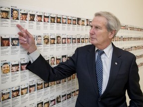 In this Oct. 25, 2017, photo, Rep. Walter Jones, R-N.C. points at a photograph of Marine Sgt. Michael Edward Bits of Ventura, Calif., the first military funeral he and his wife attended, and one of the many pictures of soldiers killed this century based in Camp Lejeune along a hallway leading to his office on Capitol Hill in Washington. As President Trump argued about what he said to the family of a soldier killed in Niger, a North Carolina congressman was quietly doing what he's done more than 11,000 times: signing a condolence letter to that family and others. Republican Rep. Walter Jones began signing the letters to families in 2003 as penance for his 2002 vote supporting war in Iraq. (AP Photo/Andrew Harnik)