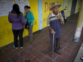 Voters wait outside a polling station during regional elections in Caracas, Venezuela, Sunday, Oct. 15, 2017. Elections could tilt a majority of the states' 23 governorships back into opposition control for the first time in nearly two decades of socialist party rule, though the government says the newly elected governors will be subordinate to a pro-government assembly. (AP Photo/Ariana Cubillos)