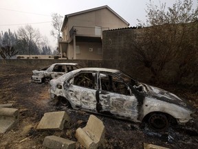 Burnt cars sit next to a house near Penacova, northern Portugal, Monday, Oct. 16 2017. Wildfires in Portugal killed at least 27 people, injured dozens more and left an unconfirmed number of missing in the country's second such tragedy in four months, officials said Monday. (AP Photo/Sergio Azenha)