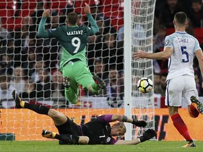 England's goalkeeper Joe Hart dives for a save in front of Slovenia's Tim Matavz during the World Cup Group F qualifying soccer match between England and Slovenia at Wembley stadium in London, Thursday, Oct. 5, 2017. (AP Photo/Kirsty Wigglesworth)