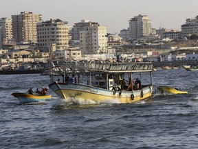Fishermen ride a boat while sail into the waters of the Mediterranean Sea in Gaza City, Wednesday, Oct. 18, 2017. Israel expanded the fishing zone for Gaza's fishermen from six nautical miles to nine miles for the two-month season. (AP Photo/Adel Hana)