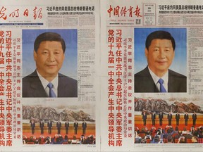 ADDS NAMES OF NEWSPAPERS - Copies of Chinese newspapers' front pages, from left to right, Renmin Ribao, Guangming Ribao,  China Sport Daily and China Youth Daily show the portrait photo of Chinese President Xi Jinping and his newly elected members of the Politburo Standing Committee of China's 19th Party Congress, in Beijing, Thursday, Oct. 26, 2017. China's ruling Communist Party has praised Xi as a Marxist thinker, adding to intense propaganda promoting his personal image as he begins a second five-year term as leader. (AP Photo/Andy Wong)