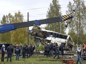 In this video grab provided by the RU-RTR Russian television via APTN, Russian Emergency Situation employees work at the scene of a derailment at a railway crossing near in the town of Pokrov, about 85 kilometers (53 miles) east of Moscow, Russia. Uzbekistan's Foreign Ministry says that 19 citizens of the ex-Soviet nation were killed when a train slammed into a bus carrying them near Moscow. (RU-RTR Russian Television/ APTN via AP)