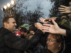 Alexei Navalny, Russia's most prominent opposition figure, left, who was released from jail after a 20-day sentence for calling an unauthorized demonstration, greets his supporters during an authorized rally in Astrakhan, about 1,300 kilometers (800 miles) southeast of Moscow, Russia, Sunday, Oct. 22, 2017. Navalny, who plans to run for president against Putin in next March's election, has repeatedly served jail terms connected to rallies. (Evgeny Feldman/Navalny Campaign via AP)
