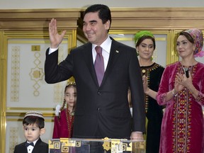 FILE - In this Sunday, Feb. 12, 2017 file photo, Turkmenistan President Gurbanguly Berdymukhamedov greets the media after casting his ballot at a polling station in Ashgabat, Turkmenistan. Turkmenistan's president on Tuesday Oct. 10, 2017, has ordered an end to free natural gas, electricity and water, which residents of the ex-Soviet nation have enjoyed for a quarter century. (AP Photo/Alexander Vershinin, File)