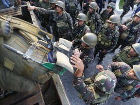 One of the first battalions to be deployed in the besieged city of Marawi in southern Philippines, board a military truck as they arrive to a hero's welcome at Villamor Air Base Friday, Oct. 20, 2017 in suburban Pasay city, southeast of Manila, Philippines. The Philippine military has begun to scale down their forces In Marawi after President Rodrigo Duterte declared its liberation following the killings of the militant leaders after five months of military offensive. (AP Photo/Bullit Marquez)