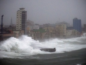 FILE - In this Sept. 9, 2017 file photo, strong waves brought by Hurricane Irma hit the Malecon seawall in Havana, Cuba. The elegant, seaside boulevard, where early 20th-century buildings are pounded with massive waves during storms and cold fronts, is now being pushed toward collapse by rising seas, more intense hurricanes, and decades of neglect. (AP Photo/Ramon Espinosa, File)
