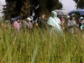 Devotees pray as they walk through a forrest in Szklarska Poreba, Czech Republic-Poland border, Saturday, Oct. 7, 2017. Polish Catholics are holding rosaries and praying together at hundreds of locations along the Poland's 3,500-kilometer (2,000-mile) border, appealing to the Virgin Mary and God for peace in Poland and in the world. (AP Photo/Petr David Josek)