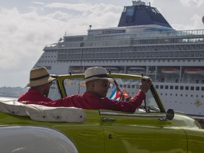 Local tour guides look for customers in their convertible car near a cruise ship docked in Havana, Cuba, Tuesday, Oct. 3, 2017. Thousands of private Cuban businesses have invested heavily in private homes, cars and restaurants, hoping to cash in on an expected wave of American travelers to the island. Now that the U.S. State Department has issued a travel warning for the country, their investments are at risk. (AP Photo/Desmond Boylan)