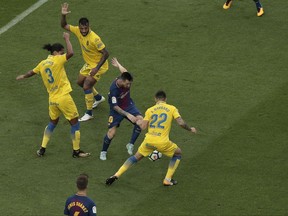 Barcelona's Lionel Messi, center, is challenged by Las Palmas' Ximo Navarro during the Spanish La Liga soccer match between Barcelona and Las Palmas at the Camp Nou stadium in Barcelona, Spain, Sunday, Oct. 1, 2017. Barcelona's Spanish league game against Las Palmas is played without fans amid the controversial referendum on Catalonia's independence. (AP Photo/Manu Fernandez)