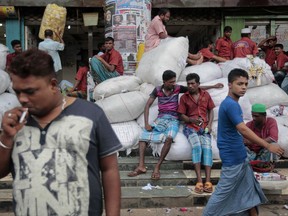 FILE - In this Aug. 13, 2016 file photo, Bangladeshi laborers wait for work at a market area in Dhaka, Bangladesh. "If necessary, Bangladeshis will eat one full meal a day and share the rest with Rohingya," Bangladeshi prime minister Sheikh Hasina said on Saturday, Oct. 7, 2017, declaring that her impoverished and overpopulated country would shelter and share what they had with the traumatized Rohingya Muslims fleeing violence and persecution in Myanmar. But some in the low-lying delta nation are worried that the staggering influx of people, if allowed to stay, could push the country's resources and economy to the brink. (AP Photo/A.M. Ahad, File)