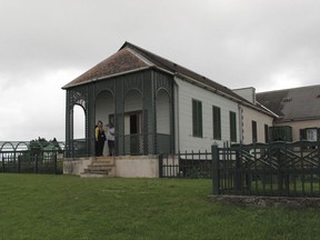 In this Oct. 14, 2017, photo, visitors stand outside Longwood House on St. Helena island where Napoleon Bonaparte lived during his exile until his death in 1821. The house is now a popular tourist attraction. St. Helena residents hope that the opening of an airport will bring more tourist revenue to their remote location, which until recently was only accessible by boat. (AP photo/Christopher Torchia)