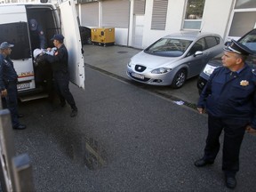 FILE - In this Sunday, Oct. 16, 2016 file photo, Montenegrin police officers escort a man suspected of planning armed attacks after the parliamentary vote, in Podgorica, Montenegro. A key witness in the trial of 14 suspected plotters to topple Montenegro's government has directly implicated an alleged Russian secret service operative in organizing the coup attempt. (AP Photo/Darko Vojinovic, File)