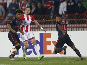 Red Star's Milan Rodic, center, challenges for the ball with Arsenal's Reiss Nelson, left, and Theo Walcott during the Europa League group H soccer match between Red Star and Arsenal on the stadium Rajko Mitic in Belgrade, Serbia, Thursday, Oct. 19, 2017. (AP Photo/Darko Vojinovic)