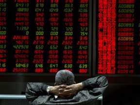 An investor looks at stock market prices on a display at a brokerage in Beijing, China, Monday, Oct. 9, 2017. Most Asian markets rose Monday following a strong week on Wall Street as Chinese trading resumed after a holiday. (AP Photo/Ng Han Guan)