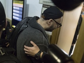 Russia's theater and film director Kirill Serebrennikov is escorted into a court room for hearings in Moscow, Russia, Tuesday, Oct. 17, 2017. Russia's Investigative Committee appealed for an extension of Serebrennikov's house arrest after he was  accused of scheming to embezzle around  $1.1 million in government funds allocated for one of his productions and the projects he championed between 2011 and 2014. (AP Photo/Pavel Golovkin)