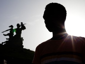 FILE- in this Oct. 2013 file photo, Alhaji,who fled Gambia after being beaten, tried, and persecuted for being gay, poses for a picture in front of the African Renaissance Monument in Dakar, Senegal. Defending gay rights can be dangerous in Africa, where many countries have laws against homosexuality. But activists in recent years stepped out of the shadows, empowered by the support of the Obama administration and the international community. Now many fear the Trump administration will undermine those gains, and that their exposure could make them more vulnerable. (AP Photo/Jane Hahn, file)