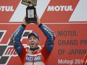 MotoGP winner Italy's Andrea Dovizioso holds up his trophy during the award ceremony of the MotoGP Japanese Motorcycle Grand Prix at the Twin Ring Motegi circuit in Motegi, north of Tokyo, Sunday, Oct. 15, 2017. (AP Photo/Shizuo Kambayashi)