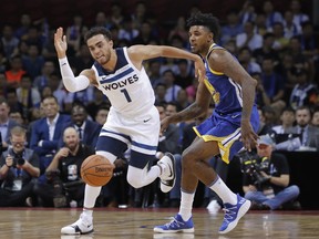 Minnesota Timberwolves' Tyus Jones, left drives past Golden State Warriors' Nick Young during the basketball match of the 2017 NBA Global Games in Shenzhen, south China's Guangdong province, Thursday, Oct. 5, 2017. (AP Photo/Kin Cheung)