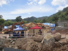 Malaysian rescuers have a briefing at a construction site after a landslide in Penang, Malaysia, Saturday, Oct. 21, 2017. Fire and rescue official Mohamad Rizuan Ramli said a 10-meter high hill slope crashed down at the construction site early Saturday. (AP Photo/Peter Ewe)