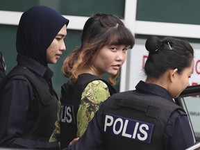 FILE - In this file picture taken Monday, Oct. 9, 2017, show Vietnamese Doan Thi Huong, escorted by police as she leaves a laboratory in Petaling Jaya, Malaysia. Evidence are stacking up against two women charged with murdering the estranged half-brother of North Korea's leader, with the banned VX nerve agent used to kill Kim Jong Nam found on their clothing and security video of the assassination presented in the first two weeks of their trial. Their governments have hired Malaysia's top criminal lawyers, who said they are unruffled by the evidence against the women so far. (AP Photo/Sadiq Asyraf, File)