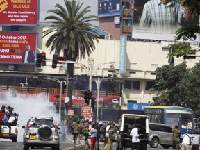 Riot police fire teargas against opposition supporters during a demonstration against the Independent Electoral and Boundaries Commission (IEBC) in Nairobi, Kenya, Friday, Oct. 13, 2017. The protesters are demanding a change of leadership at the country's election commission. The protests took place in the capital Nairobi and the opposition stronghold of Kisumu, in western Kenya, as well as in the coastal city of Mombasa.(AP Photo/Khalil Senosi)