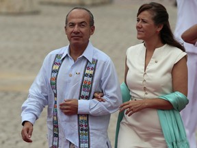 FILE - In this April 14, 2012 file photo, Mexico's President Felipe Calderon and his wife, first lady Margarita Zavala arrive for the opening ceremony of the sixth Summit of the Americas in Cartagena, Colombia. Zavala announced Friday, Oct. 6, 2017, she is resigning from the conservative National Action Party, known as the PAN. She had announced her intention to run for the party's presidential nomination, but found herself in open conflict with party leader Ricardo Anaya, who also wants the nomination. (AP Photo/Fernando Llano)