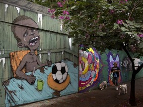 FILE - This May 23, 2014 file photo shows a mural by Brazilian street artist Paulo Ito, of a crying child who is served a soccer ball to appease his hunger, in Sao Paulo, Brazil. Prosecutors in Brazil's largest city opened an inquiry Thursday, Oct. 19, 2017, into the mayor's plans to offer school meals with pellets made of reprocessed food items. (AP Photo/Andre Penner, File)