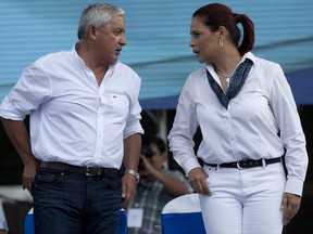 FILE - In this Jan. 12, 2014 file photo, Guatemala's President Otto Perez Molina and Vice President Roxana Baldetti, stand on a stage at the end of a rally, in Escuintla, Guatemala. On Friday, Oct. 27, 2017, a judge in Guatemala has sent the former president Baldetti to trial for corruption involving an alleged scheme in which businesses paid bribes to avoid customs duties. (AP Photo/Moises Castillo, File)