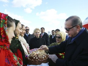 Turkey's President Recep Tayyip Erdogan, right, tries traditional Ukrainian bread after arriving in Kiev, Ukraine for an official visit, Monday, Oct. 9, 2017. Turkish officials say Turkey is asking the United States to reverse its decision to suspend non-immigrant visa services at its diplomatic facilities, following the arrest of a consulate employee, saying both countries' citizens suffer from the move.(Pool Photo via AP)