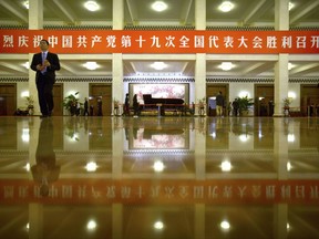 Attendees walk through the lobby of the Great Hall of the People during the closing ceremony of China's 19th Party Congress in Beijing, Tuesday, Oct. 24, 2017. China's ruling Communist Party moved Tuesday to confirm President Xi Jinping's rise to becoming the country's most powerful leader in decades by amending its constitution to add his name and ideology. The banner reads: "Warmly celebrate the successful convening of Chinese Communist Party's 19th Party Congress!" (AP Photo/Mark Schiefelbein)