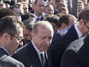 Turkish President Recep Tayyip Erdogan, center, walks through a crowd of supporters flanked by security in Novi Pazar, some 150 kilometers south of Belgrade, Serbia, Wednesday, Oct. 11, 2017. Erdogan has received a rousing welcome as he visited a predominantly Muslim region in southwestern Serbia. (AP Photo/Marko Drobnjakovic)