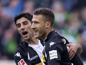 Moenengladbach's Lars Stindl , left, and scorer Fabian Johnson celebrate the opening goal during the German Bundesliga soccer match between Borussia Moenchengladbach and Bayer Leverkusen at the Borussia-Park in Moenchengladbach, Germany, Saturday, Oct. 21, 2017.  (Marius Becker/dpa via AP)