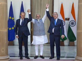 Indian Prime Minister Narendra Modi, centre, raises his hands with European Council President Donald Tusk, left, and European Commission President Jean-Claude Juncker before their meeting in New Delhi, India, Friday, Oct. 6, 2017. (AP Photo/Manish Swarup)