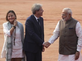 Indian Prime Minister Narendra Modi, right, shakes hand with his Italian counterpart Paolo Gentiloni, center, as Gentiloni's wife Emanuela Mauro watches during their ceremonial reception at the Indian presidential palace in New Delhi, India, Monday, Oct. 30, 2017. Gentiloni is on a two day state visit to India. (AP Photo/Manish Swarup)