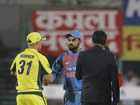 Australian cricket captain David Warner, left, shakes hand with Indian cricket captain Virat Kohli after winning the toss and electing to field during second Twenty20 cricket match in Gauhati, India, Tuesday, Oct. 10, 2017. (AP Photo/Manish Swarup)