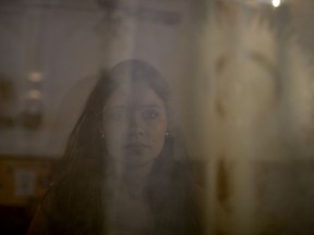 In this Oct. 11, 2017 photo, Mailin Gobbo, 29, poses for a photo taken through a curtained window at San Jose Obrero church where Catholic priest Carlos Jose officiated Mass in Caseros, in the province of Buenos Aires, Argentina. Gobbo says she was abused as a child by the priest, and decided to speak publicly after the birth of her daughter. (AP Photo/Natacha Pisarenko)