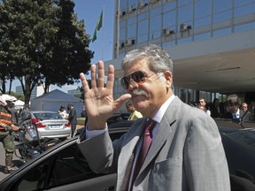 FILE- In this April 20, 2012 file photo, Argentina's then Planning Minister Julio de Vido waves to media as he leaves the Ministry of Mines and Energy in Brasilia, Brazil. Argentina's Congress is considering stripping De Vido of his immunity as current legislator, since he is being accused of corruption. (AP Photo/Eraldo Peres)
