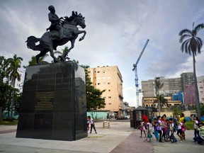 School children look at a bronze statue immortalizing Jose Marti donated by the Bronx Museum of the Arts, after it's unveiling in Havana, Cuba, Friday, Oct. 20, 2017. The statue is a replica of a statue that has been in New York's Central Park since the 1950's. (AP Photo/Ramon Espinosa)
