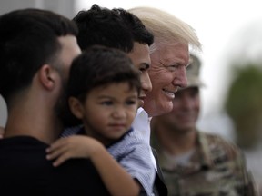 President Donald Trump poses for a photo as he visits a disaster relief distribution center at Calgary Chapel in Guaynabo, Puerto Rico, Tuesday, Oct. 3, 2017. Trump is visiting Puerto Rico in the wake of Hurricane Maria.(AP Photo/Evan Vucci)