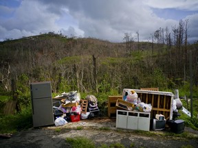 This Saturday, Oct. 14 2017 photo shows personal belongings recovered from a home destroyed by Hurricane Maria, in Morovis, Puerto Rico. Nearly a month after the hurricane made landfall, Puerto Rico is only beginning to come to grips with a massive environmental emergency that has no clear end in sight. With hundreds of thousands of people still without running water, and 20 of the island's 51 sewage treatment plants out of service, there are growing concerns about contamination and disease. (AP Photo/Ramon Espinosa)
