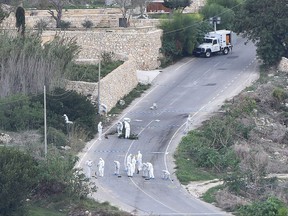 Forensic police work on the main road in Bidnija, Malta, which leads to Daphne Caruana Galizias house, looking for evidence on the blast that killed the journalist as she was leaving her home, Thursday, Oct. 19, 2017. Caruana Galizia, a harsh critic of Maltese Premier Joseph Muscat, and who reported extensively on corruption on Malta, was killed by a car bomb on Monday. (AP Photo/Rene Rossignaud)
