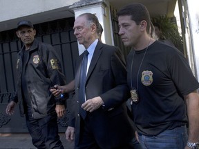 Carlos Nuzman, President of the Brazilian Olympic Committee, center, is escorted by federal police officers after being taken into custody at his home, in Rio de Janeiro, Brazil, Thursday, Oct. 5, 2017. The president of the Brazilian Olympic Committee was arrested amid an investigation into a vote-buying scheme to bring the Olympics to Rio de Janeiro last year. (AP Photo/Silvia Izquierdo)