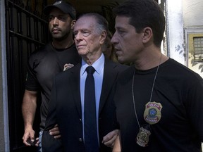 FILE - In this Oct. 5, 2017 file photo, Carlos Nuzman, president of the Brazilian Olympic Committee, is escorted by federal police officers after being taken into custody at his home, in Rio de Janeiro, Brazil. Nuzman was charged by Brazilian prosecutors Wednesday, Oct. 18, 2017, with corruption, money laundering, tax evasion, and running a criminal organization. (AP Photo/Silvia Izquierdo, File)