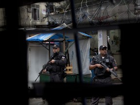 Police officers patrol in the Rocinha slum, in Rio de Janeiro, Brazil, Monday, Oct. 23, 2017. Brazilian military police say officers killed a Spanish tourist when the vehicle she was traveling in came under fire after ignoring a police checkpoint. A military police statement says the incident followed a firefight between police officers and suspected drug traffickers early Monday in Rocinha, one of Brazil's largest slums.  (AP Photo/Silvia Izquierdo)