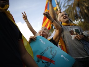 People cheer during a rally in Barcelona, Spain, Tuesday, Oct. 10, 2017. Catalonia's president Puigdemont will address the regional parliament in a session during which a declaration of independence could be made based on the results of a disputed Oct. 1 independence referendum opposed by Spanish central authorities. (AP Photo/Francisco Seco)