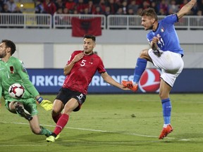 Albania's goalkeeper Etrit Berisha, left, saves a shot by Italy's Ciro Immobile, right, as Albania's Frederic Veseli looks on during the World Cup Group G qualifying soccer match between Albania and Italy at Loro Borici stadium, in Shkoder, northern Albania, Monday, Oct. 9, 2017. (AP Photo/Hektor Pustina)
