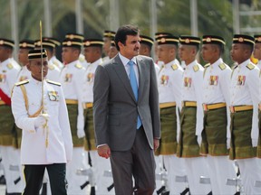 Qatar's Emir Sheikh Tamim bin Hamad Al Thani, center, inspects an honor guard during a welcome ceremony at parliament house in Kuala Lumpur, Malaysia, Monday, Oct. 16, 2017. (AP Photo/Vincent Thian)