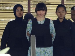Vietnamese Doan Thi Huong, center, is escorted by police as she leave the court house in Shah Alam, Malaysia, Tuesday, Oct. 3, 2017. Thi Huong and Siti Aisyah of Indonesia pleaded not guilty as their trial opened Monday in the killing of Kim, widely thought to have been orchestrated by his half brother, North Korea's third-generation leader Kim Jong Un. (AP Photo/Vincent Thian)